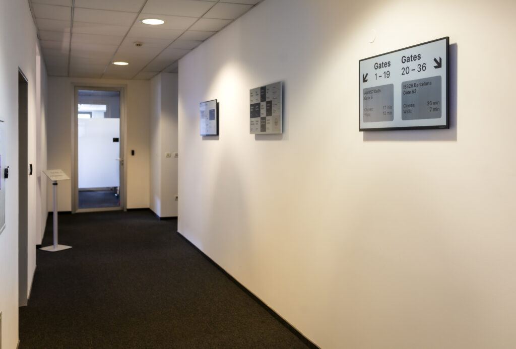 Hallway with three 32" Place&Play displays for new visitors and workers.